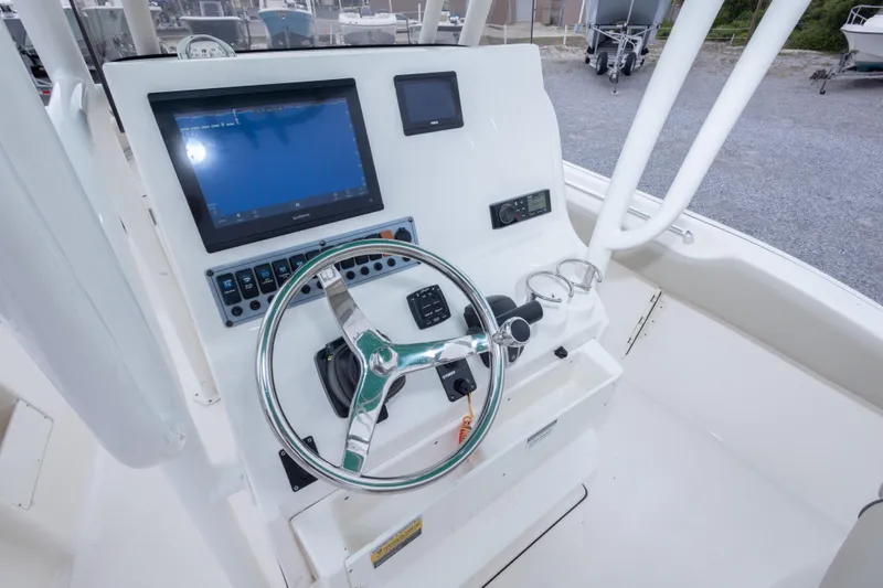 Slide: The Image of 2023 Key West 239 FS boat dashboard with steering wheel and navigation display. - 33