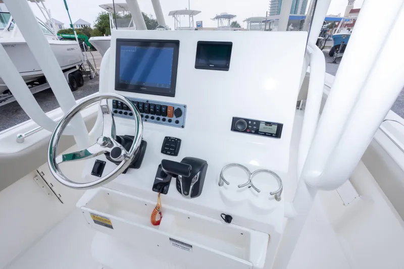Slide: The Image of 2023 Key West 239 FS boat console with steering wheel, controls, and display screens. - 34