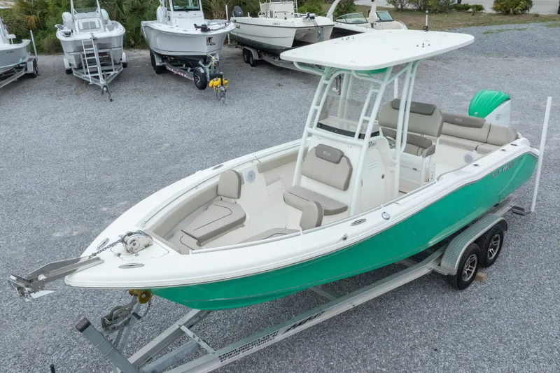 Slide: The Image of 2023 Key West 239 FS boat on trailer, vibrant green hull, parked among other boats. - 4