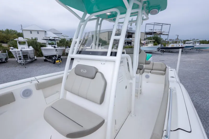 Slide: The Image of 2023 Key West 239 FS boat interior with seating and console, parked in a marina. - 42