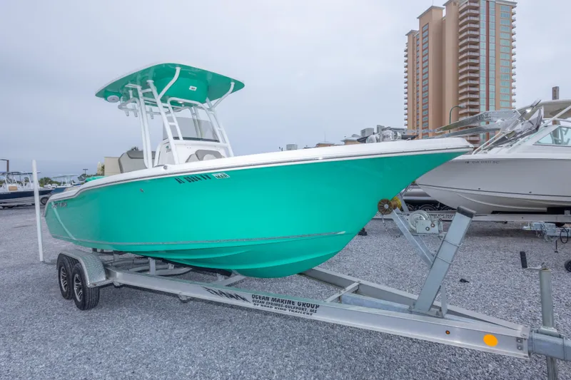 Slide: The Image of 2023 Key West 239 FS boat on trailer, vibrant teal hull, urban backdrop. - 8