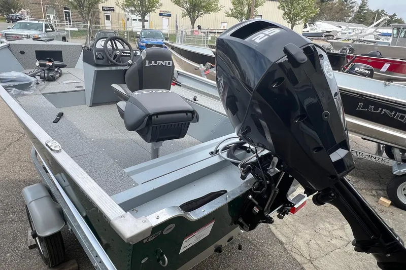Slide: The Image of 2026 Lund 1400 Fury SS boat with outboard motor, parked on a trailer. - 10