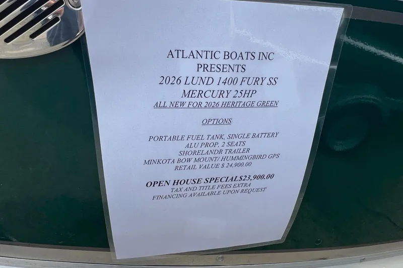 Slide: The Image of 2026 Lund 1400 Fury SS boat details with pricing and options listed on a display sign. - 15