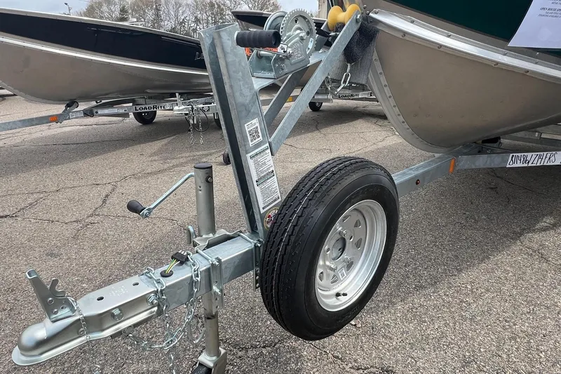 Slide: The Image of Trailer hitch and wheel of 2026 Lund 1400 Fury SS boat on pavement. - 17