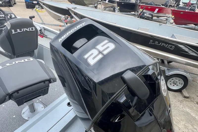 Slide: The Image of 2026 Lund 1400 Fury SS boat with Mercury 25 engine, displayed in a showroom. - 19