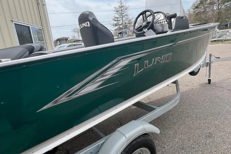 Slide: The Image of 2026 Lund 1400 Fury SS boat on trailer, green exterior, parked outdoors. - 3