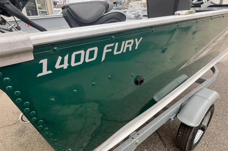 Slide: The Image of 2026 Lund 1400 Fury SS boat, green exterior, on a trailer, side view. - 5