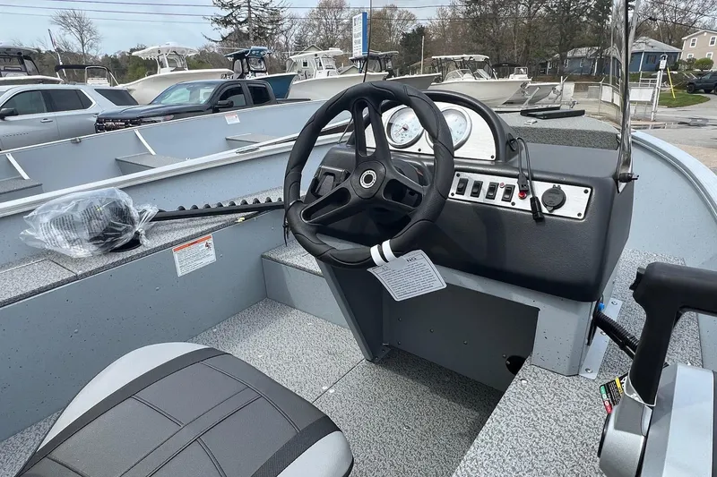 Slide: The Image of 2026 Lund 1400 Fury SS boat interior with steering wheel and control panel. - 6