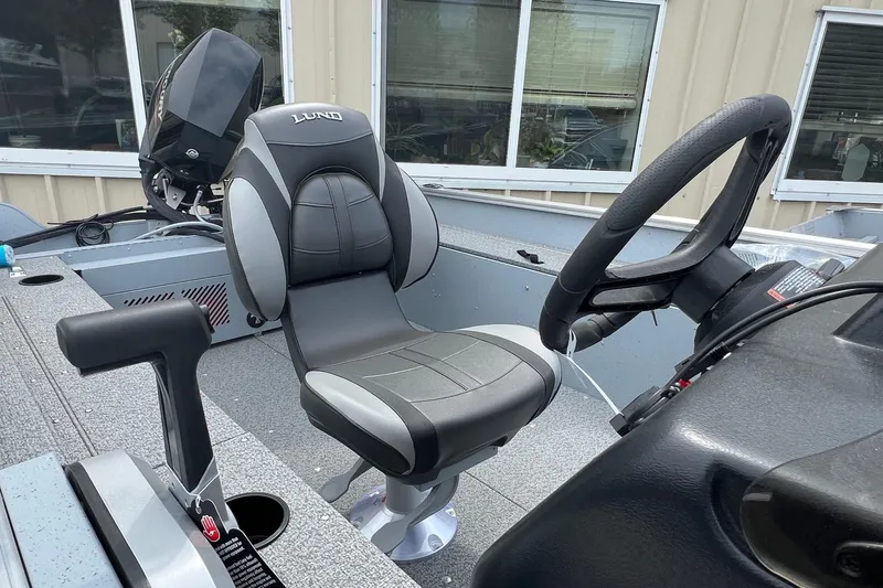 Slide: The Image of 2026 Lund 1400 Fury SS boat interior with steering wheel and seat. - 7