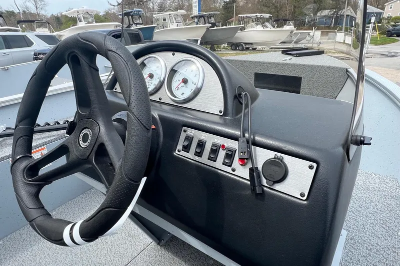 Slide: The Image of 2026 Lund 1400 Fury SS boat dashboard with steering wheel and control panel. - 8