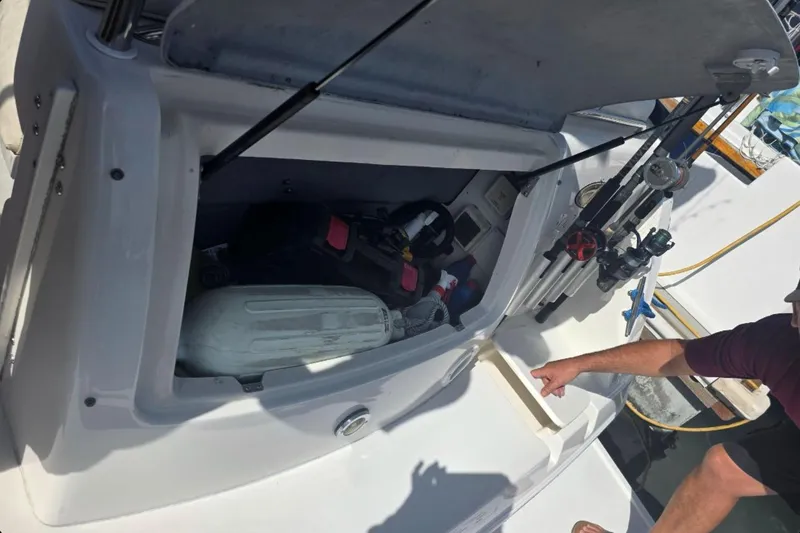Slide: The Image of Open storage compartment on a 2000 Monterey 302 Cruiser boat with fishing gear. - 13