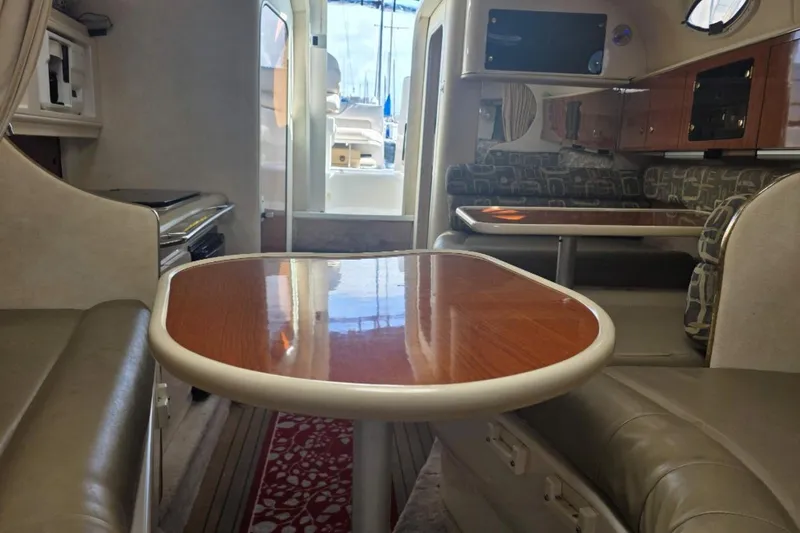 Slide: The Image of Interior of a 2000 Monterey 302 Cruiser with wood-finish tables and cushioned seating. - 6
