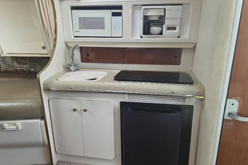 Slide: The Image of Compact kitchen in a 2000 Monterey 302 Cruiser with microwave, coffee maker, and sink. - 7