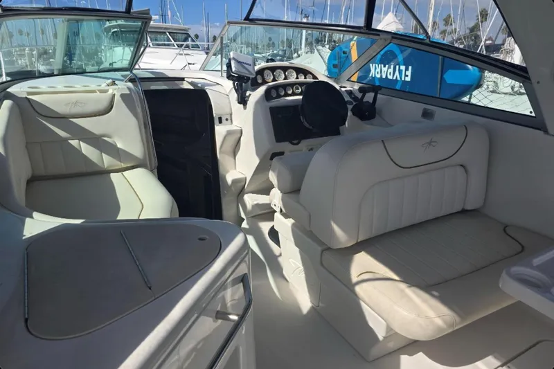 Slide: The Image of Interior of a 2000 Monterey 302 Cruiser boat with white seating and dashboard. - 9