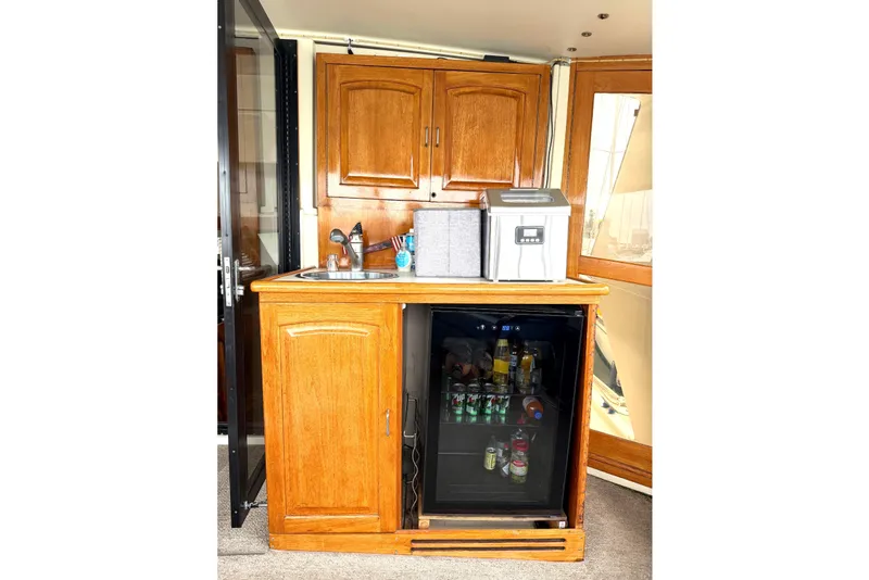 Slide: The Image of 1989 45' Californian Aft Cabin Motor Yacht interior with wooden cabinetry and mini fridge. - 11