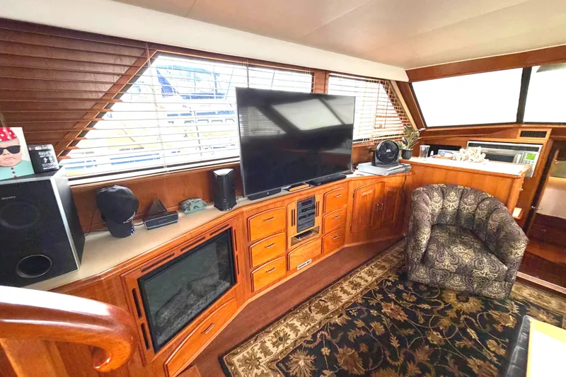 Slide: The Image of 1989 45' Californian Aft Cabin Motor Yacht interior with TV, fireplace, and patterned chair. - 24