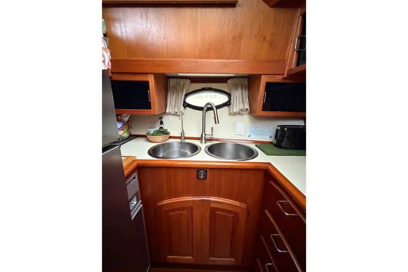 Slide: The Image of 1989 45' Californian Aft Cabin Motor Yacht kitchen with dual sinks and wooden cabinetry. - 27