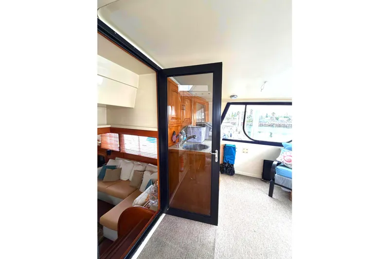 Slide: The Image of Interior view of 1989 45' Californian Aft Cabin Motor Yacht with cozy seating and large windows. - 7