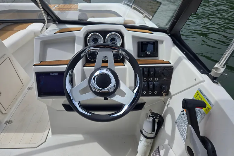 Slide: The Image of 2023 Starcraft SVX 210 DC OB boat dashboard with steering wheel and controls. - 10