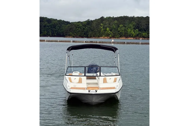 Slide: The Image of 2023 Starcraft SVX 210 DC OB boat on a calm lake with forested background. - 2