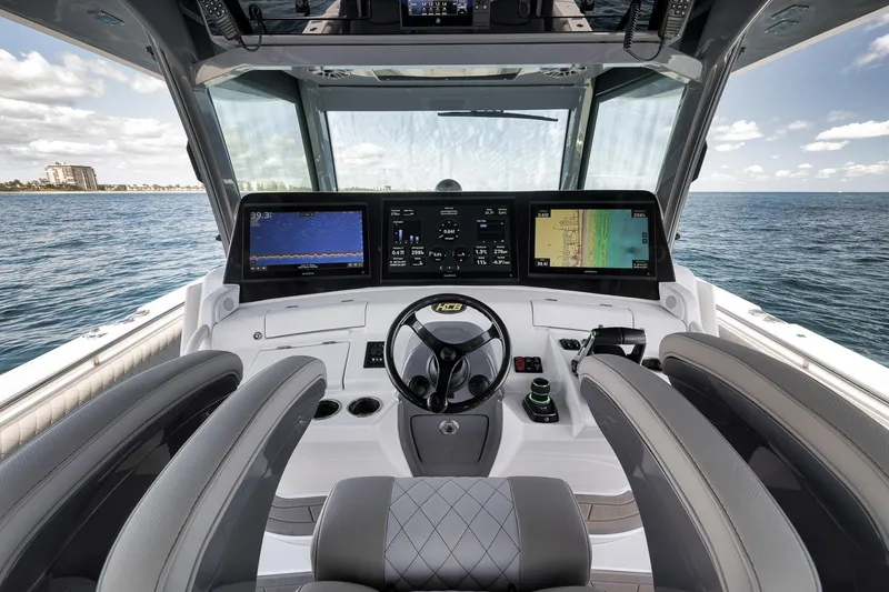 Slide: The Image of Helm of 2025 HCB 53 Suenos boat with advanced navigation displays on open sea. - 22
