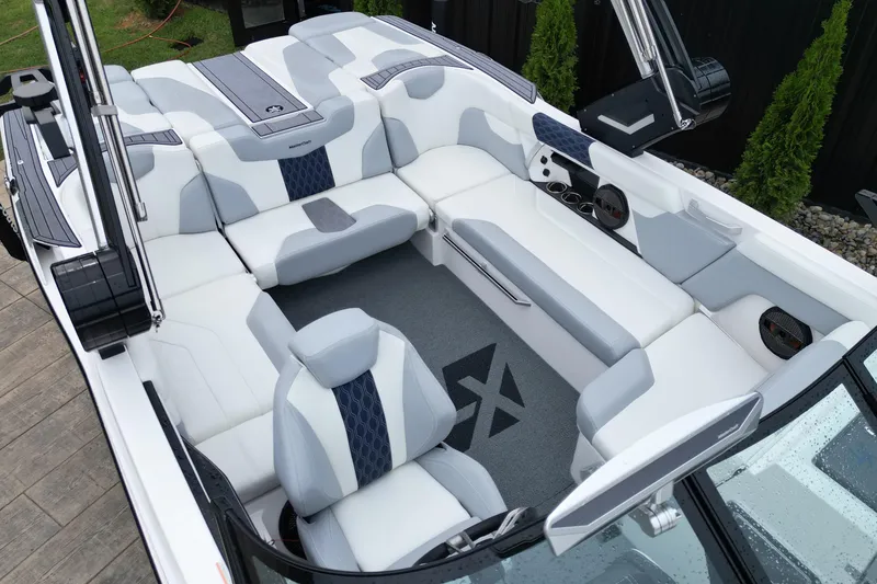 Slide: The Image of 2023 MasterCraft XT22 boat interior with sleek white and gray seating design. - 11