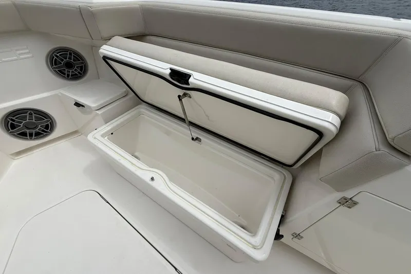 Slide: The Image of Open storage compartment on 2022 Solace 41CS boat with cushioned seating and speakers. - 10