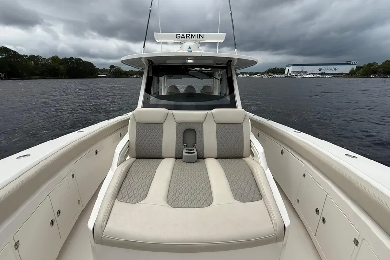 Slide: The Image of 2022 Solace 41CS boat with cushioned seating, on a cloudy day, near a marina. - 11