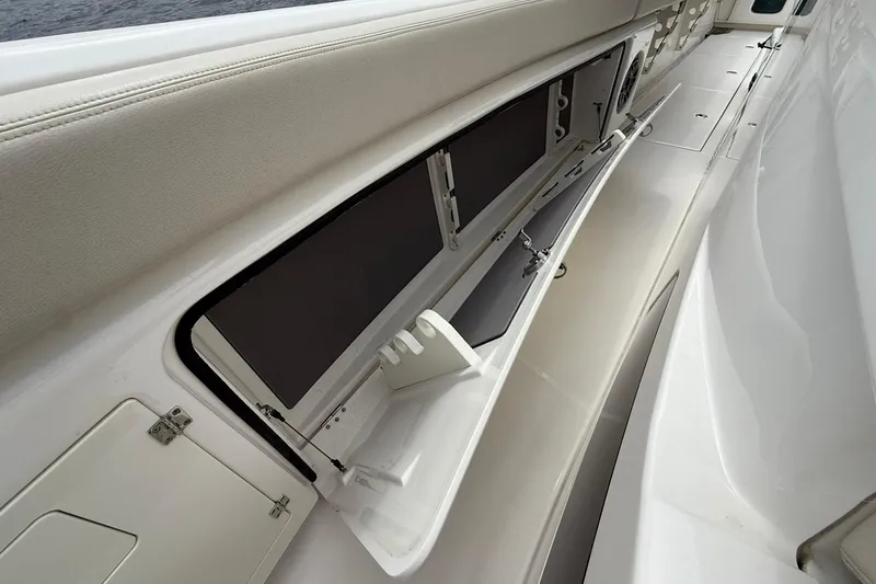 Slide: The Image of 2022 Solace 41CS boat interior storage compartment with open hatch and rod holders. - 19