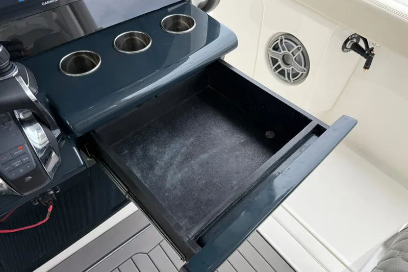Slide: The Image of Open storage drawer on Solace 41CS boat, featuring cup holders and control panel. - 30