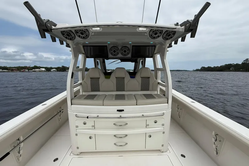 Slide: The Image of 2022 Solace 41CS boat interior with seating and storage, on a calm water backdrop. - 33