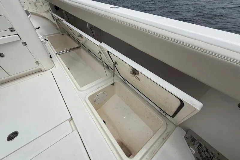 Slide: The Image of 2022 Solace 41CS boat with open storage compartments on deck, near the ocean. - 39