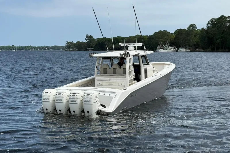 Slide: The Image of 2022 Solace 41CS boat with four outboard engines on a calm lake. - 4