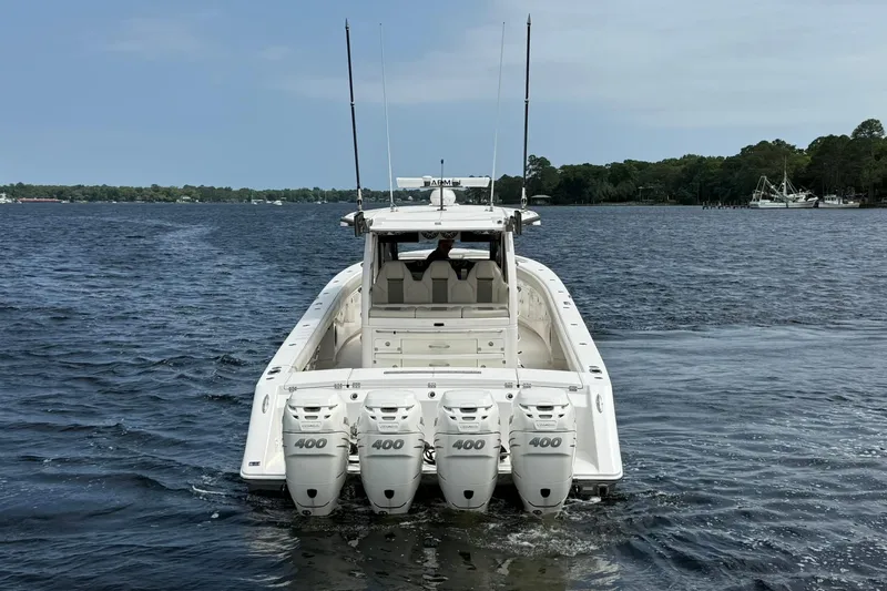 Slide: The Image of 2022 Solace 41CS boat with four powerful outboard engines on a calm lake. - 5