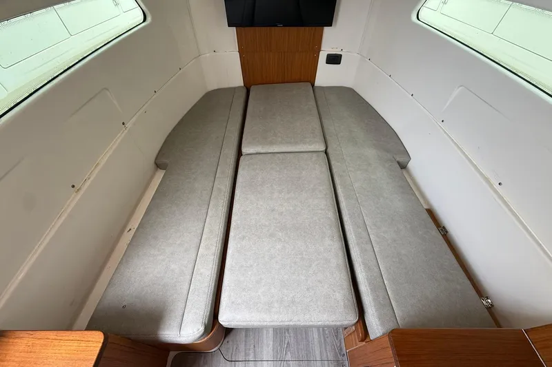 Slide: The Image of 2022 Solace 41CS cabin interior with gray cushioned seating and wooden accents. - 62