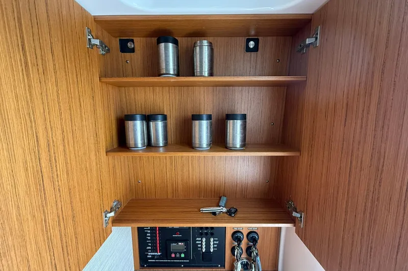 Slide: The Image of Wooden cabinet with stainless steel containers and control panel in a 2022 Solace 41CS boat. - 65