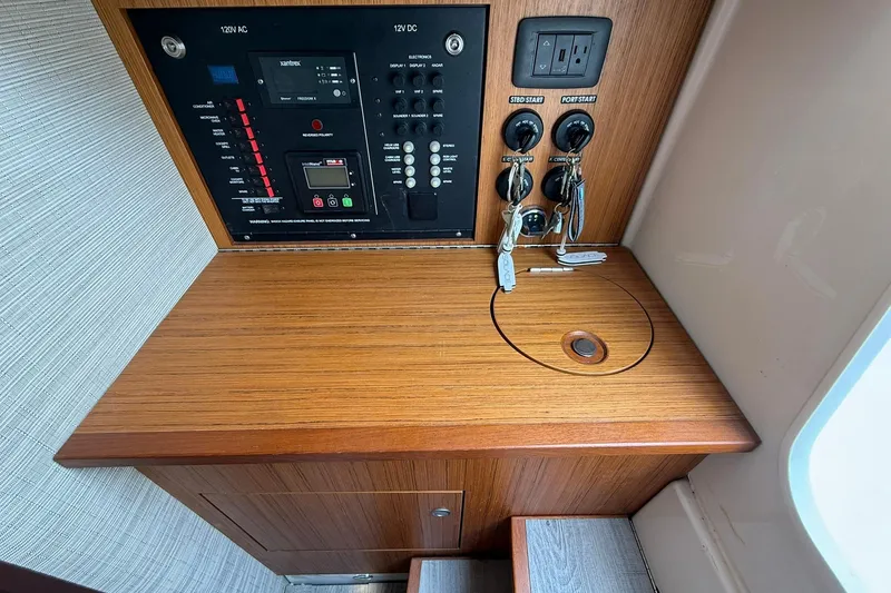 Slide: The Image of Control panel and keys on a 2022 Solace 41CS boat, featuring wood finish. - 66
