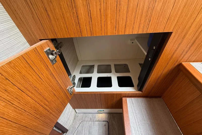 Slide: The Image of 2022 Solace 41CS interior storage compartment with wooden finish and organized bins. - 67