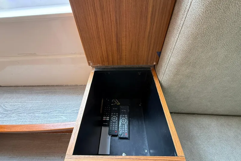 Slide: The Image of Hidden storage compartment in Solace 41CS 2022, containing remote controls. - 69