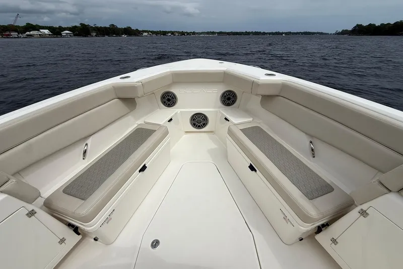 Slide: The Image of 2022 Solace 41CS boat interior with cushioned seating and speakers on a calm lake. - 7
