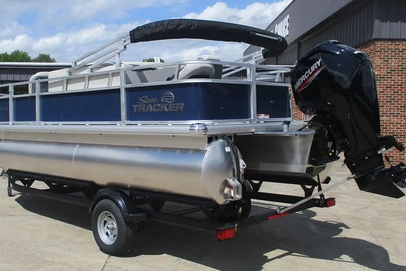 Slide: The Image of 2026 Sun Tracker Bass Buggy 18 DLX pontoon boat with Mercury outboard motor on trailer. - 5