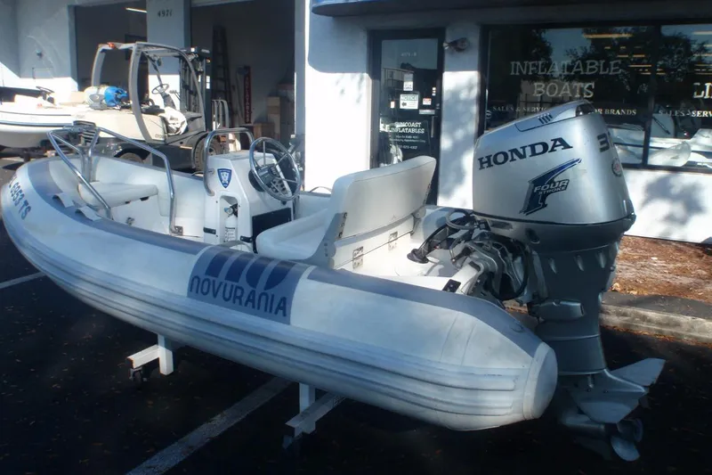 Slide: The Image of 2007 Novurania Deluxe 335 inflatable boat with Honda outboard motor, parked outside a dealership. - 4
