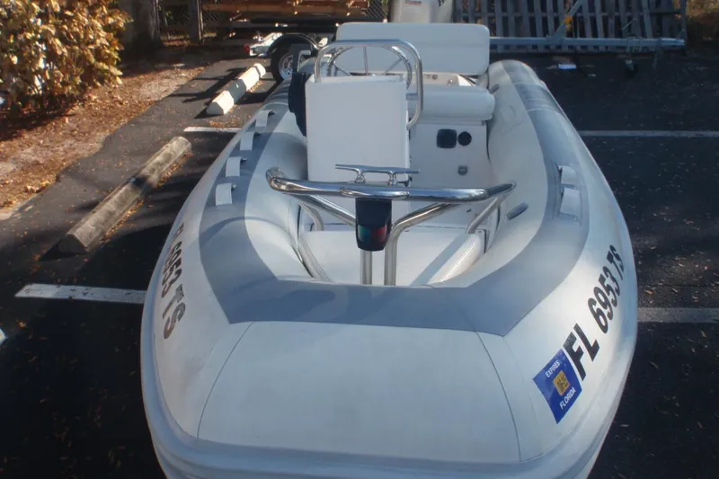 Slide: The Image of 2007 Novurania Deluxe 335 inflatable boat parked in a lot, featuring white and gray design. - 7