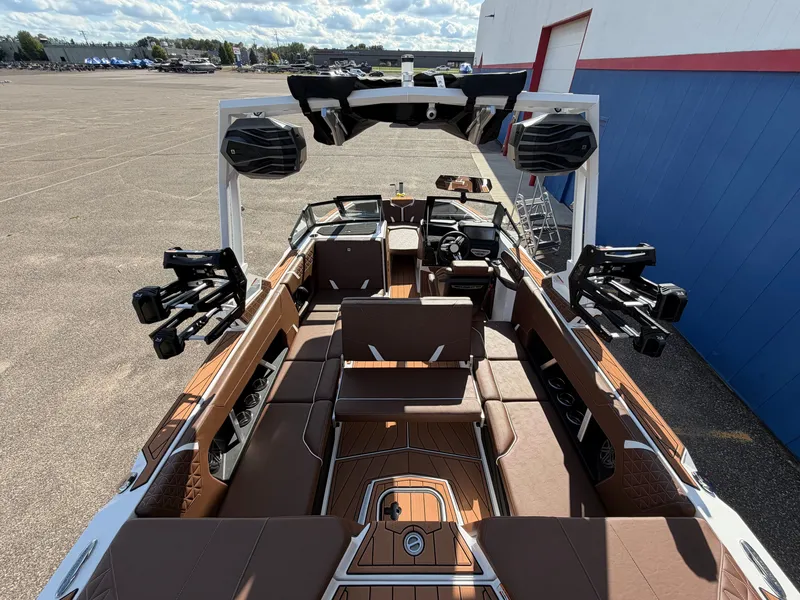 Slide: The Image of The image shows the interior of a 2027 Nautique GS22 Super Air boat. It features brown upholstery and modern speakers. - 45
