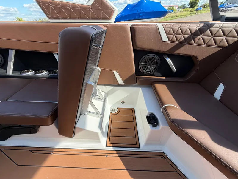 Slide: The Image of Interior of a 2027 Nautique GS22 Super Air with brown upholstery and modern speakers. - 31