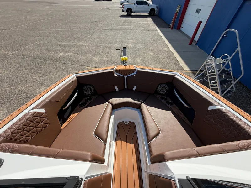 Slide: The Image of The image shows the bow of a 2027 Nautique GS22 Super Air with brown upholstery and speakers. - 14
