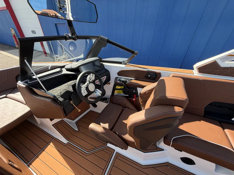 Slide: The Image of The image shows the cockpit of a 2027 Nautique GS22 Super Air with brown leather seats and a modern dashboard. - 25