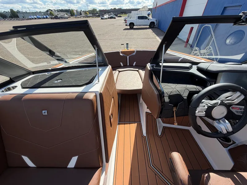 Slide: The Image of Interior view of a modern boat with brown seats and wood flooring, parked in a lot. - 18
