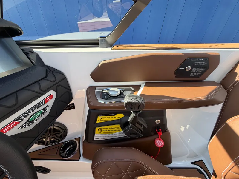 Slide: The Image of The 2027 Nautique GS22 Super Air cockpit features a modern control system with brown leather seating. - 22
