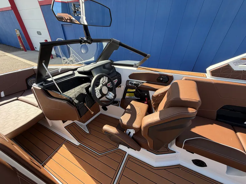 Slide: The Image of The image shows the cockpit of a 2027 Nautique GS22 Super Air with brown leather seats and a modern helm. - 24